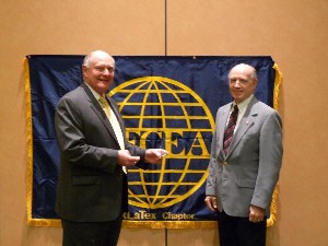 Lo Walker (r), mayor of Bossier City, Louisiana, presents a city coin to D'Agostino in honor of his presentation at the chapter's February meeting.

